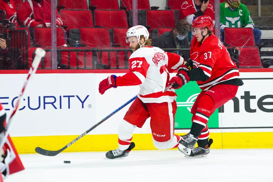 Detroit Red Wings center Michael Rasmussen tries to control the puck against Carolina Hurricanes right wing Andrei Svechnikov at PNC Arena in Raleigh, N.C., April 29, 2021.