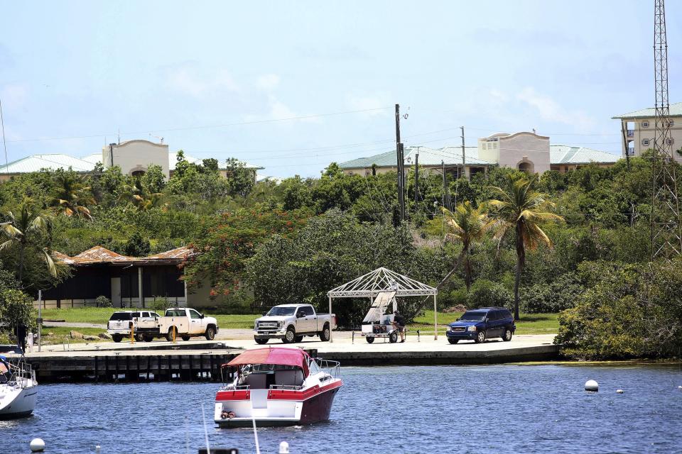 Vehicles are parked on a government dock in Red Hook where FBI agents were seen last Monday boarding a boat, in St. Thomas, U.S. Virgin Islands, Wednesday, Aug. 14, 2019. Curiosity in St. Thomas peaked this week as a group of FBI agents descended on nearby Little St. James Island and carried away what locals say were several large items from one of two islands that the 66-year-old Jeffery Epstein owned. (AP Photo/Gabriel Lopez Albarran)