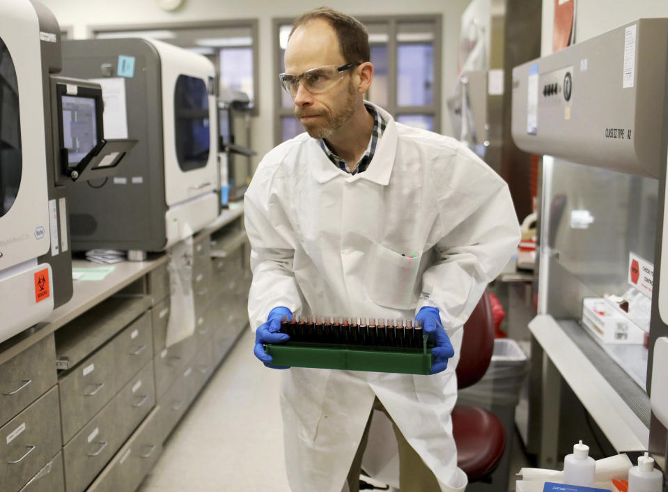 In this March 10, 2020, photo, Brian Howell, a lab technologist, works on the extracting of RNA from a sample in the Mayo virology lab at the Mayo Clinic Superior Drive facility in Rochester, Minn. Vice President Mike Pence has an appointment Tuesday at Minnesota’s Mayo Clinic to learn about a new coronavirus testing “moonshot” that has the famed clinic partnering with the state and its flagship university to quickly boost the state's capacity to 20,000 tests a day. (David Joles/Star Tribune via AP)