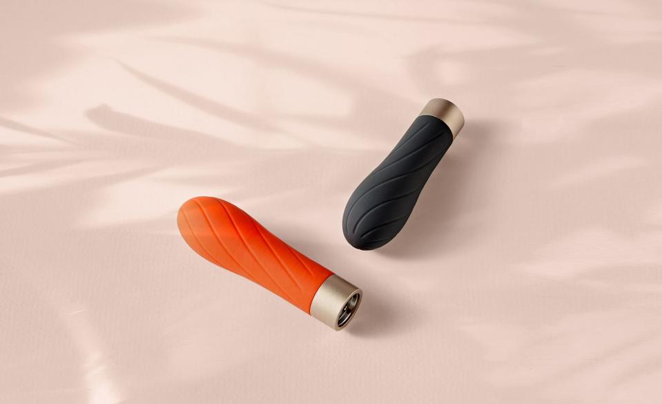 a close up of two vibrators on a pink background