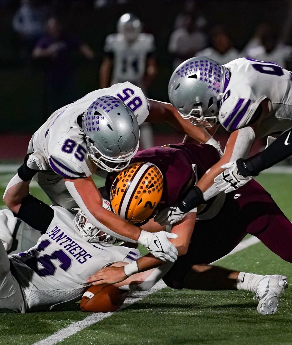 Bloomington South’s Ben Godar (16), Tysen Smith (85) and Noah Fox (90) and Bloomington North quarterback Dash King battle for possession of a fumble during the IHSAA sectional semi-final football game at Bloomington North on Friday, Oct. 27, 2023.