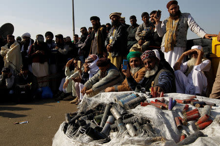 Supporters of the Tehrik-e-Labaik Pakistan Islamist political party listen to their leader Khadim Hussain Rizvi (not pictured) as he speaks with the media, beside a sack full of shotgun and teargas shell casings used on them by police, at their protest site at Faizabad junction in Islamabad, Pakistan November 27, 2017. REUTERS/Caren Firouz