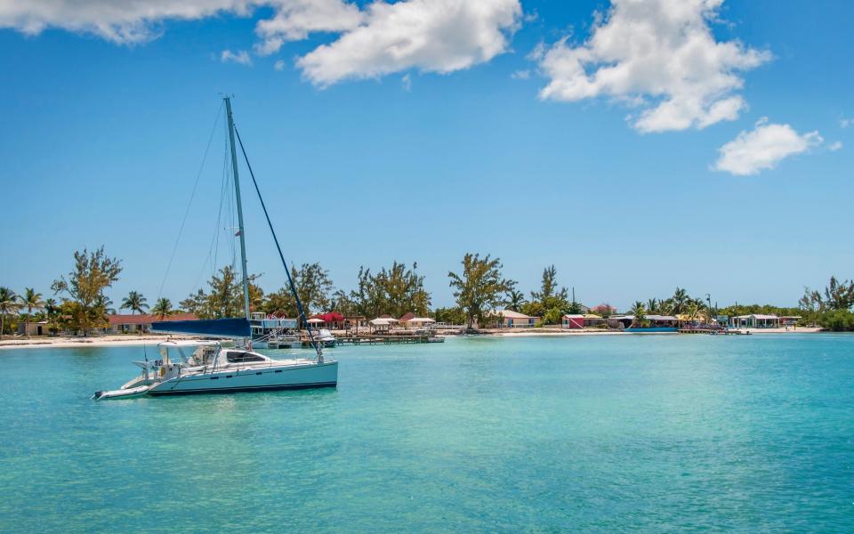 The Caribbean island of Anegada, with a clear bright sky and tropical blue-green water - Getty