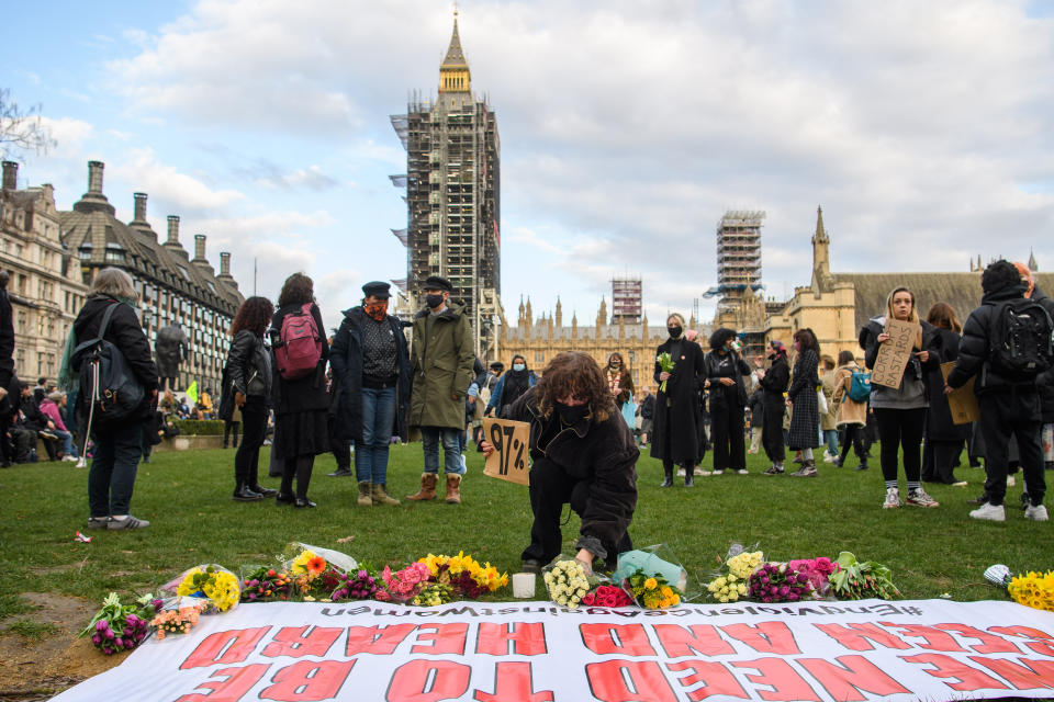 A woman leaves flowers in Parliament Square, central London, in memory of Sarah Everard.