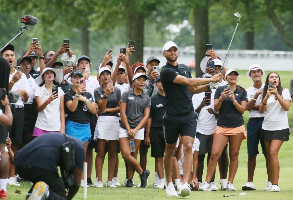 Underrated Golf tour players watch as Stephen Curry hits his fifth attempt  to replicate Tiger Wood's famous shot in the dark on the 18th hole on the South Course at Firestone Country Club in Akron.