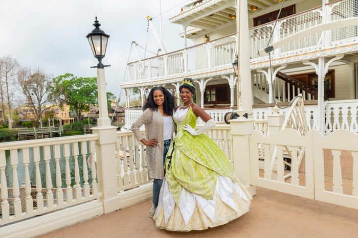 Tiana greeting guests at a Disney theme park.