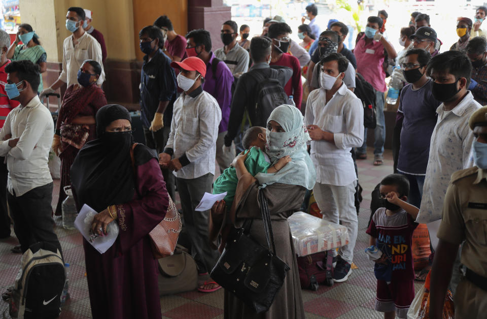 Passengers wait outside Hyderabad Railway Station to catch a train to return to their home states in Hyderabad, India, Monday, June 1, 2020. More states opened up and crowds of commuters trickled onto the roads in many of India's cities on Monday as a three-phase plan to lift the nationwide coronavirus lockdown started despite an upward trend in new infections. (AP Photo/Mahesh Kumar A.)