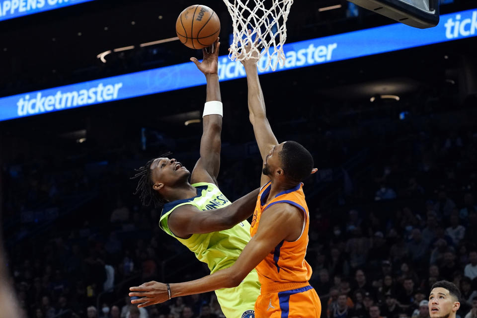 Minnesota Timberwolves forward Anthony Edwards shoots as Phoenix Suns forward Mikal Bridges, right, defends during the first half of an NBA basketball game, Friday, Jan. 28, 2022, in Phoenix. (AP Photo/Matt York)