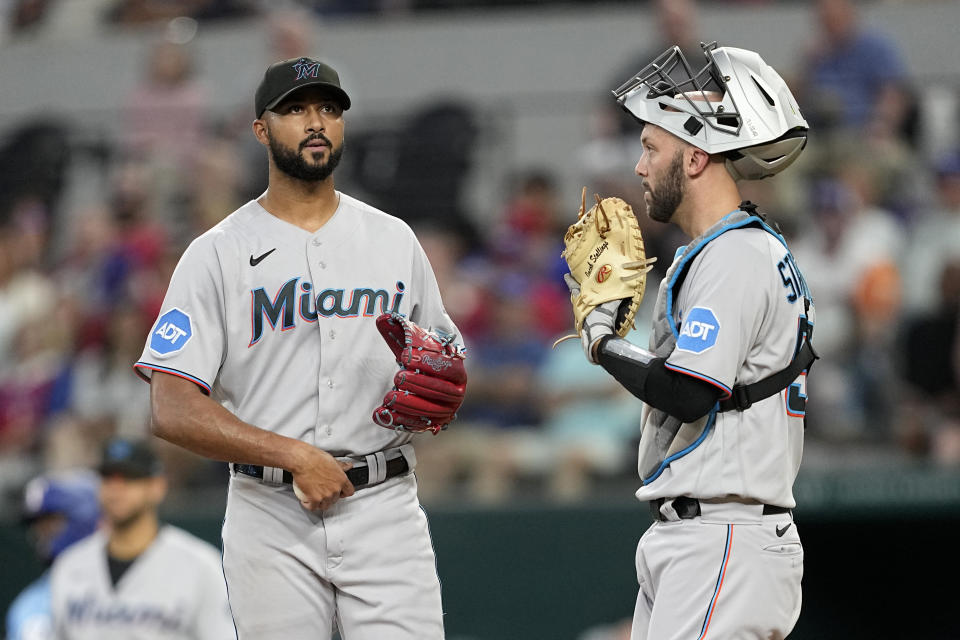 Miami Marlins starting pitcher Sandy Alcantara, left, and catcher Jacob Stallings, right, talk during a mound visit in the third inning of a baseball game against the Texas Rangers, Sunday, Aug. 6, 2023, in Arlington, Texas. (AP Photo/Tony Gutierrez)