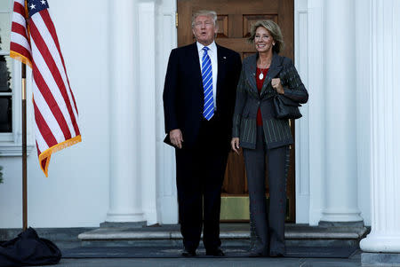 U.S. President-elect Donald Trump (L) stands with Betsy DeVos after their meeting at the main clubhouse at Trump National Golf Club in Bedminster, New Jersey, U.S., November 19, 2016. REUTERS/Mike Segar