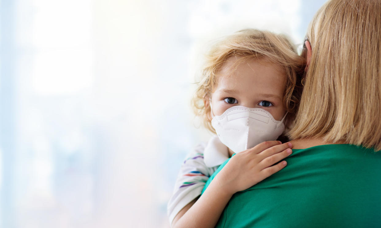 Family with kids in face mask in shopping mall or airport. Mother and child wear facemask during coronavirus and flu outbreak. Virus and illness protection, hand sanitizer in public crowded place.