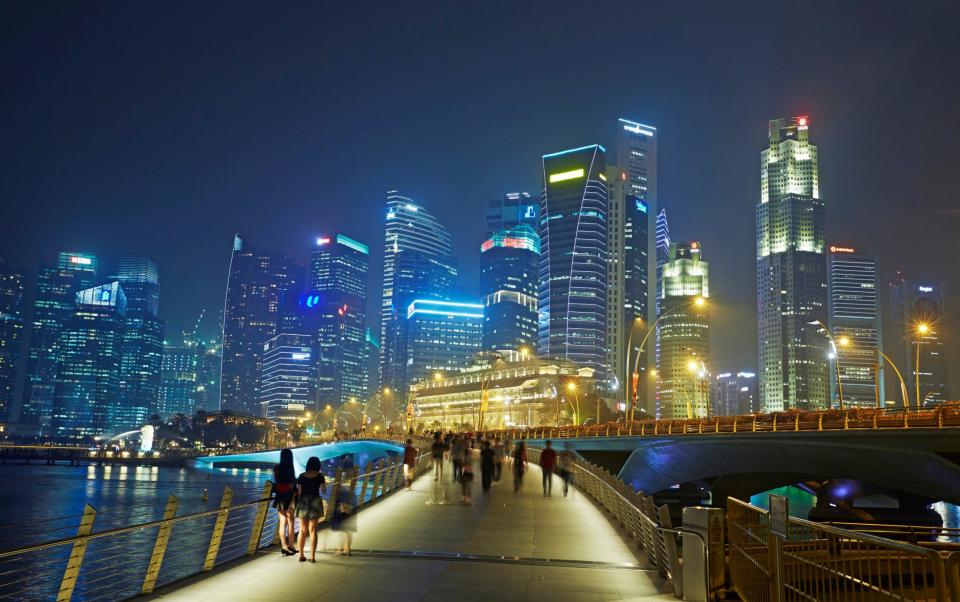 Skyline of skyscrapers in the financial district of Singapore and Marina Bay illuminated at night - Allan Baxter