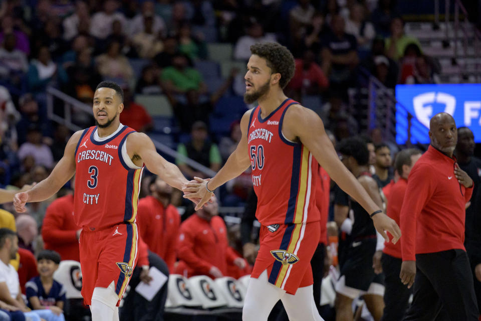 New Orleans Pelicans guard CJ McCollum (3) celebrates after a score with forward Jeremiah Robinson-Earl (50) as Portland Trail Blazers head coach Chauncey Billups, right, looks back during the second half of an NBA basketball game in New Orleans, Saturday, March 16, 2024. (AP Photo/Matthew Hinton)