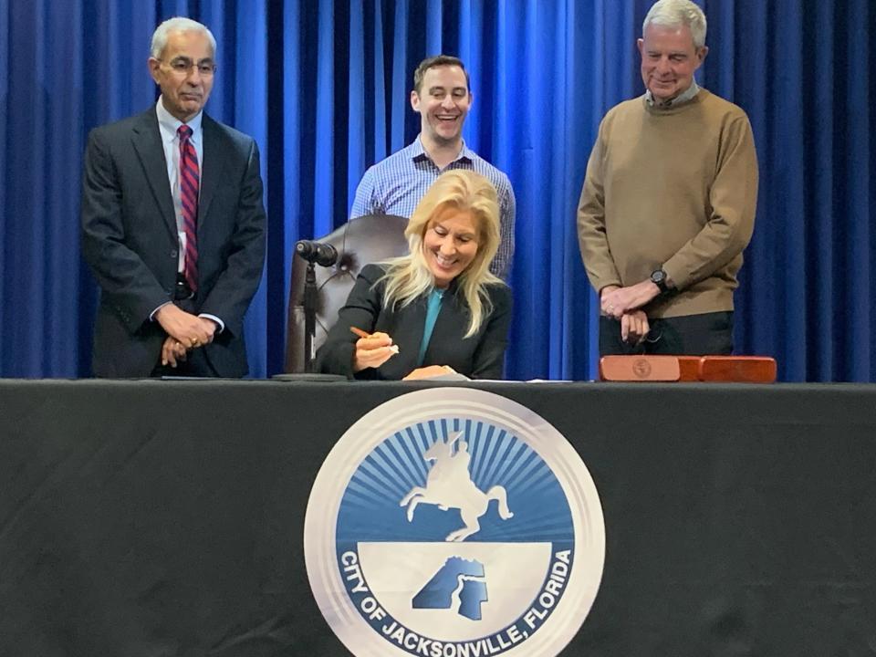 Mayor Donna Deegan signs the recommendations of her transition committees on Dec. 13, after City Council passed the final version of the bill the night prior. Council members Ron Salem, from left, Jimmy Peluso and Michael Boylan stand behind her.