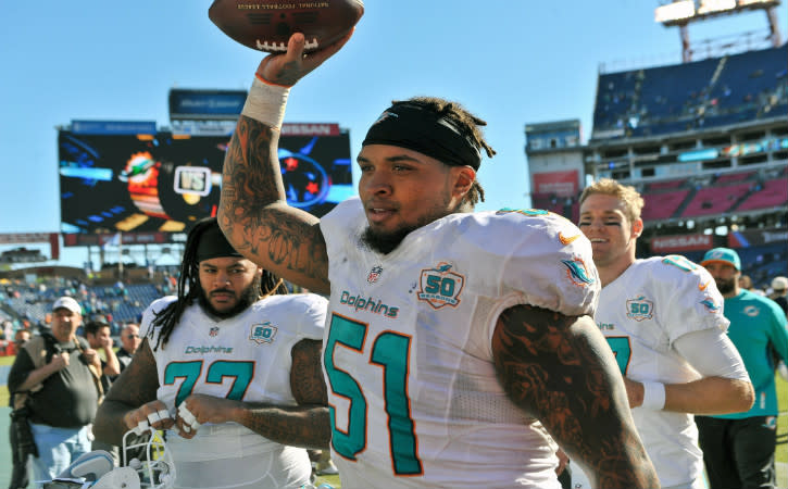 Oct 18, 2015; Nashville, TN, USA; Miami Dolphins center Mike Pouncey (51) celebrates as he leaves the field after his team defeated the Tennessee Titans at Nissan Stadium. Miami won 38-10. Mandatory Credit: Jim Brown-USA TODAY Sports