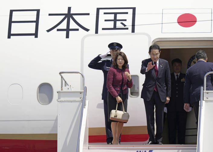 Japanese Prime Minister Fumio Kishida, center, and his wife Yuko wave as they depart for Hiroshima to attend the G7 summit, at Haneda airport in Tokyo, Thursday, May 18, 2023. (Kyodo News via AP)