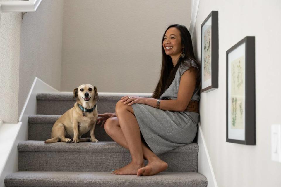 Elizabeth Nguyen sits with her dog at her home in Davis on May 26. Her book “Aloha Vietnam” is a fictionalized account based on her family history fleeing Vietnam and struggling with bipolar disorder.