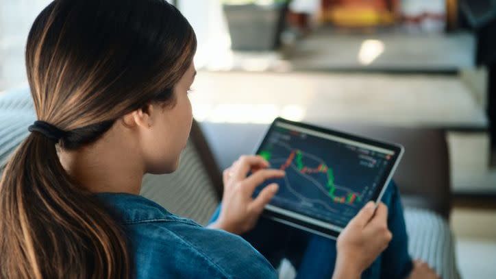 A woman tracks the performance of one of the investments in her portfolio. 