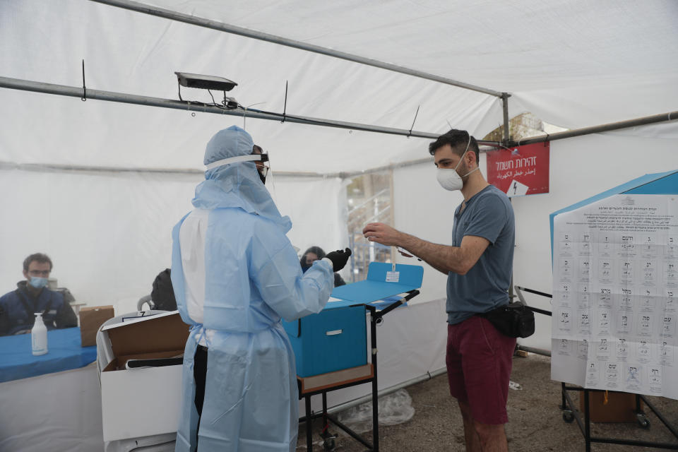 A man votes for Israel's parliamentary election at a special polling station for people who are in quarantine for coronavirus in Jerusalem, Tuesday, March 23, 2021. (AP Photo/Maya Alleruzzo)