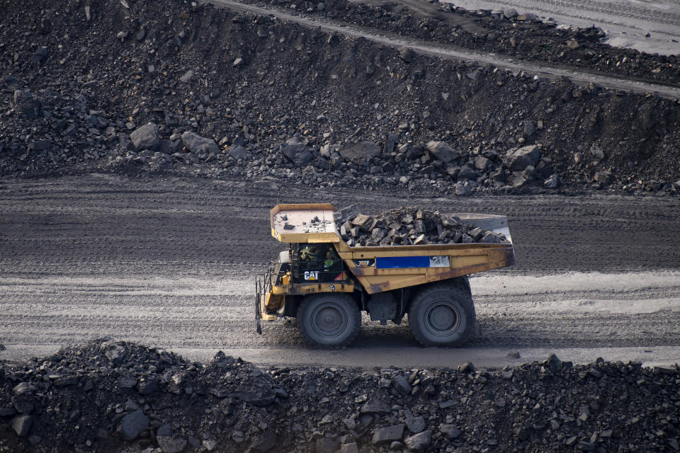 A yellow truck driving inside a coal mine. (Source: Getty)