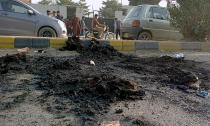 Local residents gather at the site where a Sri Lankan citizen was lynched by Muslim mob outside a factory in Sialkot, Pakistan, Friday, Dec. 3, 2021. A Muslim mob attacked a sports equipment factory in Pakistan's eastern Punjab province on Friday, killing a Sri Lankan over allegations of blasphemy, police said. (AP Photo/Shahid Akram)