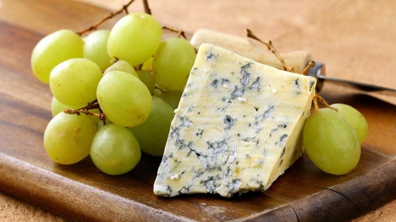 Green grapes and blue cheese on board