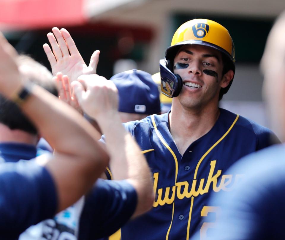 Brewers DH Christian Yelich gets congrats in the dugout after hitting for the cycle against the Reds on Wednesday in Cincinnati.