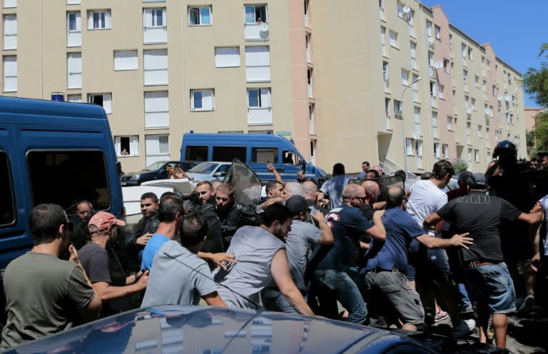 Hundreds walk into the cite des Monts surrounded by policemen in Lupino on August 14, 2016 in Bastia on the French Mediterranean island of Corsica