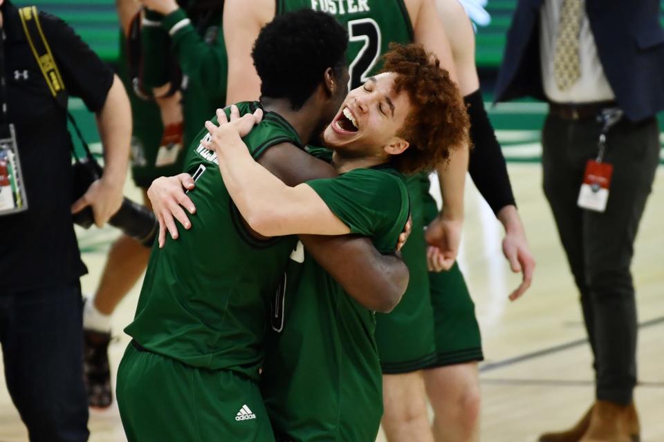 Ohio guard Jason Preston, right, hugs forward Dwight Wilson III in celebration after the Bobcats beat the Buffalo Bulls to win the MAC championship at Rocket Mortgage FieldHouse in Cleveland, March 13, 2021.