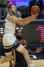 Minnesota Timberwolves forward Jake Layman, top, shoots over Golden State Warriors guard Brad Wanamaker during the first half of an NBA basketball game in San Francisco, Monday, Jan. 25, 2021. (AP Photo/Jeff Chiu)