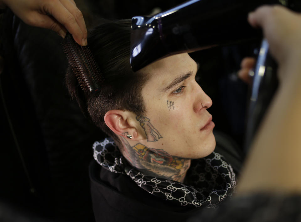 Jimmy Q. of London, England has his hair done backstage before the Fall 2014 DKNY collection is modeled during Fashion Week in New York, Sunday, Feb. 9, 2014. (AP Photo/Seth Wenig)