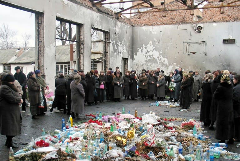 Friends and relatives of victims killed in the 2004 Beslan school hostage massacre gather on March 3, 2005 in the remains of the school in North Ossetia for a minute's silence to commemorate the six-month anniversary of the tragedy