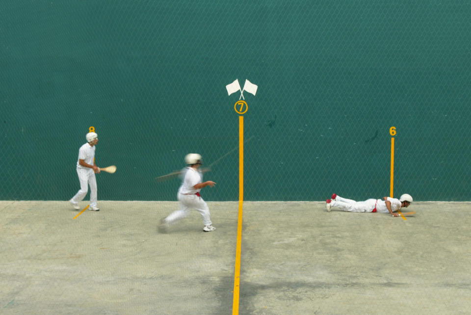 Three men playing Pelota