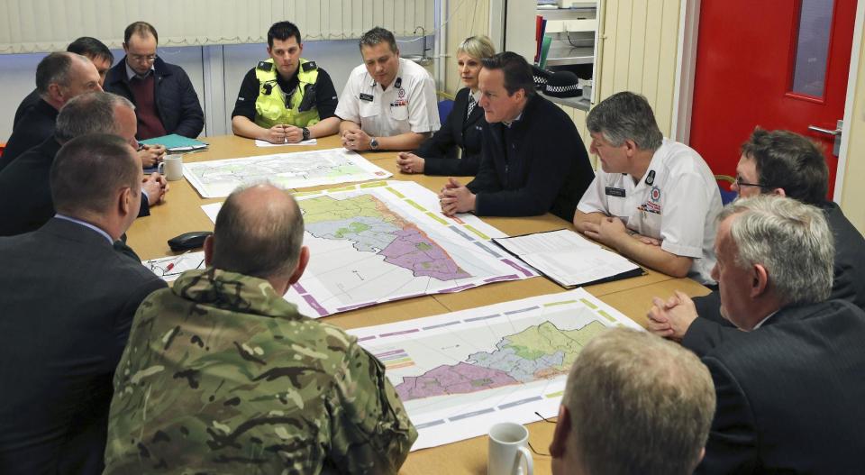 Britain's Prime Minister David Cameron talks to representatives from the emergency services, military, Network Rail and power companies about the recent bad weather in Britain, at Bispham Fire Station, Blackpool, Lancashire, England, Friday, Feb. 14, 2014. (AP Photo/PA, Peter Byrne) UNITED KINGDOM OUT