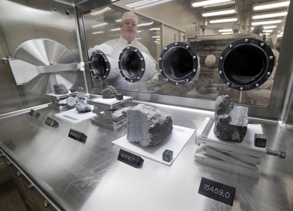 Ryan Zeigler, Apollo sample curator, left, stands next to a nitrogen-filled case displaying various lunar samples collected during Apollo missions 15, 16 and 17, inside the lunar lab at the NASA Johnson Space Center Monday, June 17, 2019, in Houston. (Photo: Michael Wyke/AP)