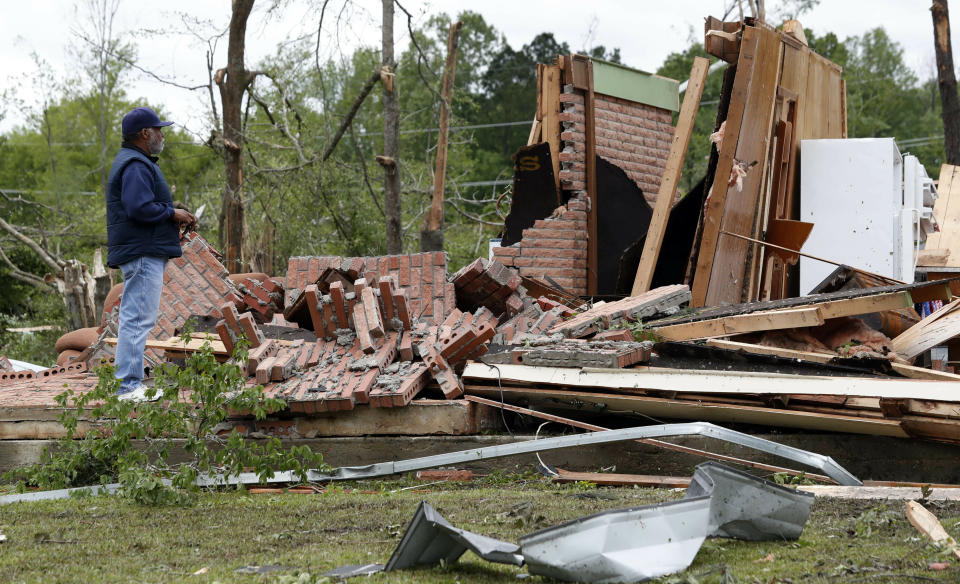 A friend of the owner reviews the remains of a storm damaged house in Morton, Miss., Friday, April 19, 2019, following a possible tornado touchdown Thursday afternoon, as strong storms again roared across the South on Thursday, topping trees and leaving a variety of damage in Mississippi, Louisiana and Texas. (AP Photo/Rogelio V. Solis)