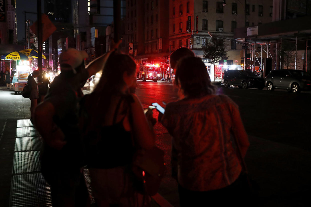 Pedestrians looks at their cellphones during a power outage in midtown Manhattan, Saturday, July 13, 2019, in New York. (Photo: Michael Owens/AP)