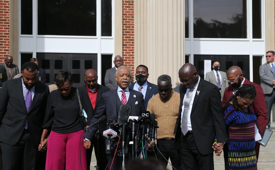 The Rev. Al Sharpton prays with Wanda Cooper-Jones and Marcus Arbery, the parents of slain jogger Ahmaud Arbery, on Nov. 10 in front of the Glynn County Courthouse in Brunswick, Georgia. More than 100 Black pastors and religious leaders rallied in support of the family.