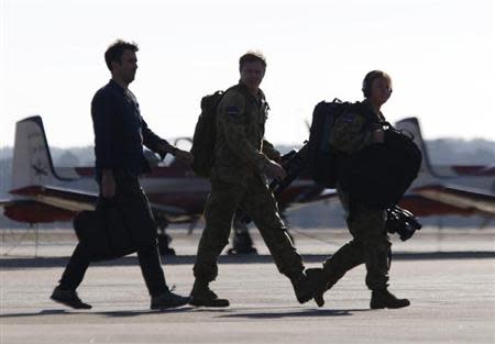 Royal Australian Air Force crew members talk from their AP-3C Orion aircraft upon its early return to RAAF base Pearce near Perth, March 27, 2014. REUTERS/Jason Reed