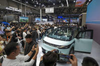 Visitors take photos of a Zeekr car during the opening of China Auto Show in Beijing, China, Thursday, April 25, 2024. (AP Photo/Tatan Syuflana)