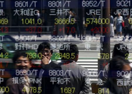 People are reflected in a stock quotation board outside a brokerage in Tokyo April 23, 2015. REUTERS/Toru Hanai