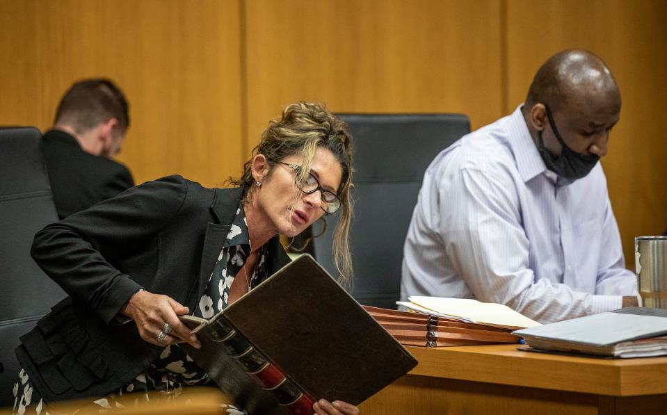 Defense attorney Debra Tuomey looks up case law for Marcelle Waldon during his first-degree murder trial Thursday. The defense and prosecution argued Thursday over case law regarding immunity for testimony.