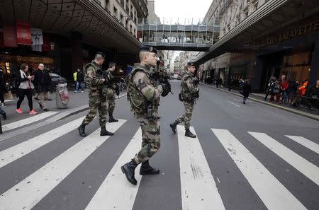 French soldiers patrol in the street near a department store in Paris as part of the highest level of "Vigipirate" security plan in Paris January 10, 2015. French police searched for a female accomplice to militant Islamists behind deadly attacks on the satirical Charlie Hebdo weekly newspaper and a kosher supermarket and maintained a top-level anti-terrorist alert ahead of a Paris gathering with European leaders and demonstration set for Sunday. REUTERS/Eric Gaillard