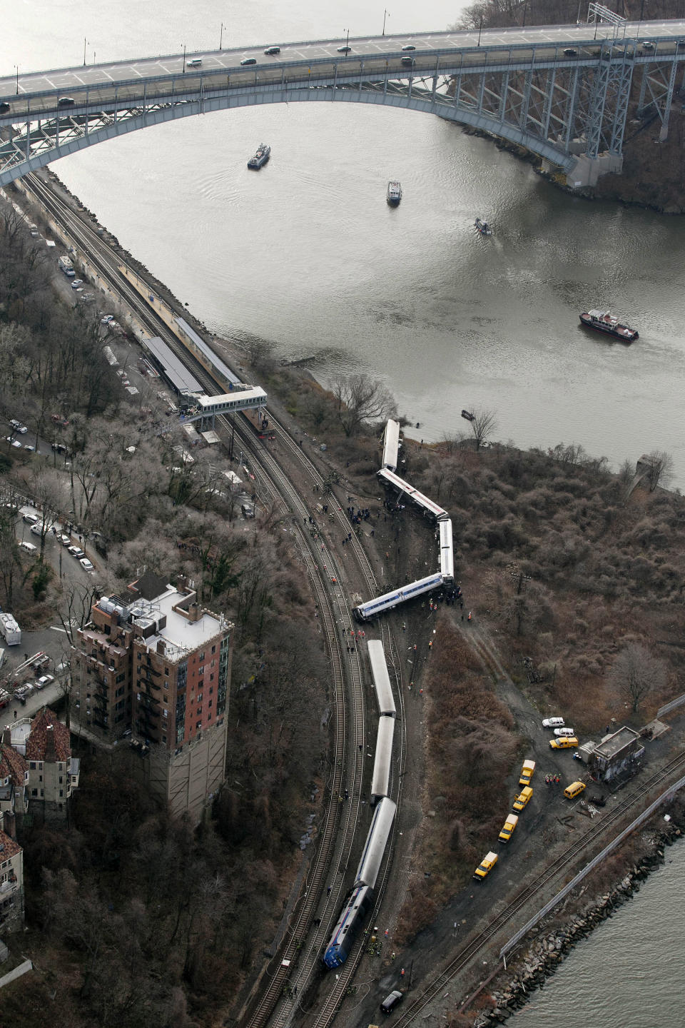 FILE - In this Dec. 1, 2013 file photo, a Metro-North passenger train lays on it's side after derailing on a curved section of track in the Bronx borough of New York. According to a Federal Railroad Administration review prompted by the derailment that killed four passengers and injured about 70 others, the Metro-North commuter railroad has allowed its emphasis on trains' on-time performance to "routinely" overshadow its safety operations. (AP Photo/Mark Lennihan, File)