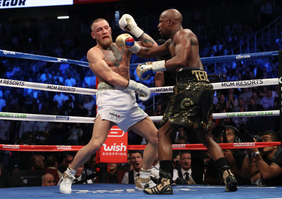 LAS VEGAS, NV - AUGUST 26:  (R-L) Floyd Mayweather Jr. throws a punch at Conor McGregor during their super welterweight boxing match on August 26, 2017 at T-Mobile Arena in Las Vegas, Nevada.  (Photo by Christian Petersen/Getty Images)