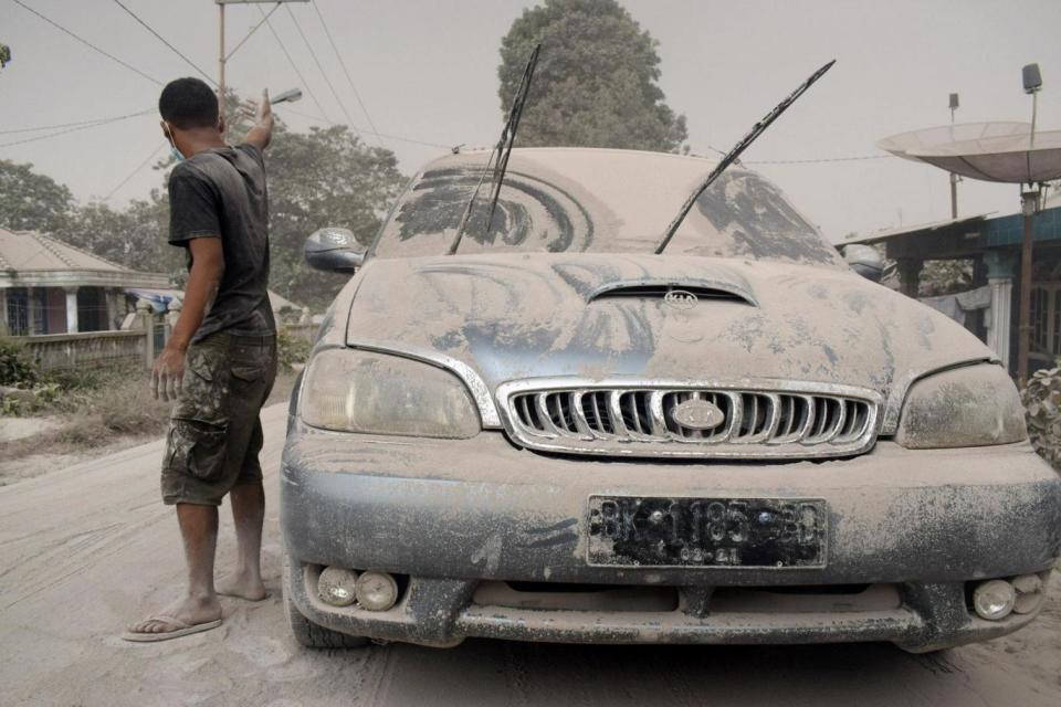 Blanketed: Ash settled on roads, houses and parked cars (REUTERS)