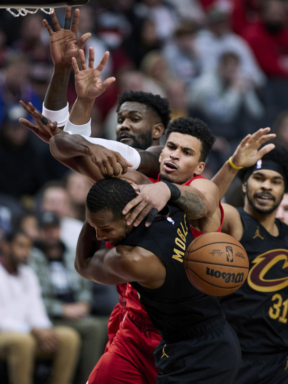 Portland Trail Blazers forward Toumani Camara, center, and center Deandre Ayton, back left, and Cleveland Cavaliers forward Evan Mobley, front, and center Jarrett Allen, right, reach for a rebound during the second half of an NBA basketball game in Portland, Ore., Wednesday, Nov. 15, 2023. (AP Photo/Craig Mitchelldyer)