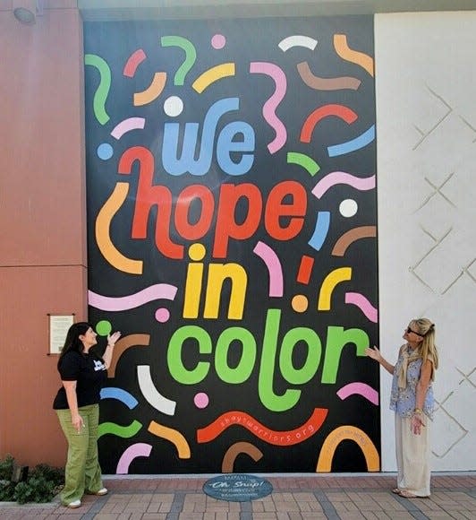 Shay Moraga shows Sandie Newton her mural on El Paseo in Palm Desert.