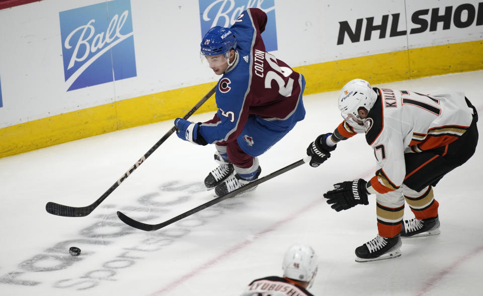 Colorado Avalanche center Ross Colton, left, drives to the net with the puck as Anaheim Ducks left wing Alex Killorn pursues in the first period of an NHL hockey game Wednesday, Nov. 15, 2023, in Denver. (AP Photo/David Zalubowski)