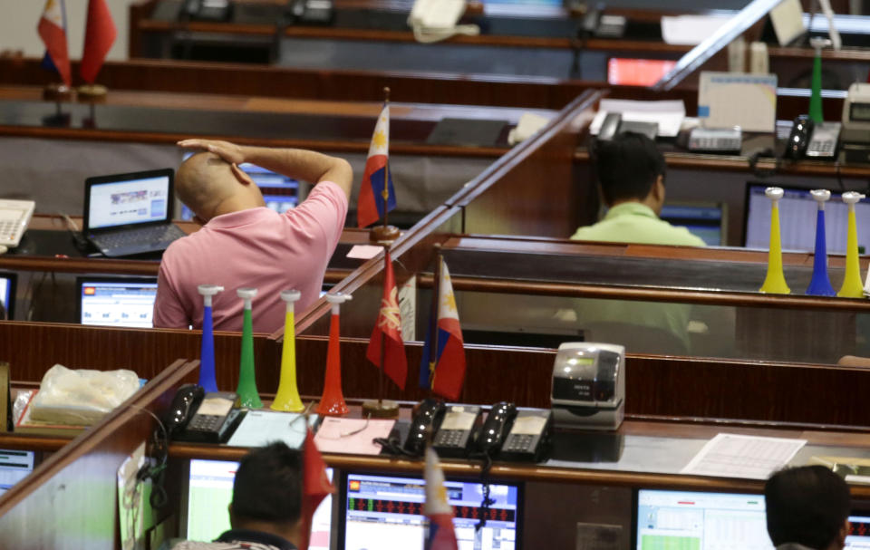 A trader gestures while monitoring the trading at the Philippines Stocks Exchange at the financial district of Makati city, east of Manila, Philippines Friday Jan.3, 2014. Elsewhere, in Asia, Tokyo was closed for the New Year's holiday. Seoul's main index lost 2.2 percent to 1,967.1, while Taiwan's Taiex was flat at 8,612.5. Benchmarks in Malaysia and Thailand also fell. India's Sensex added 0.5 percent to 21,239.0. (AP Photo/Bullit Marquez)